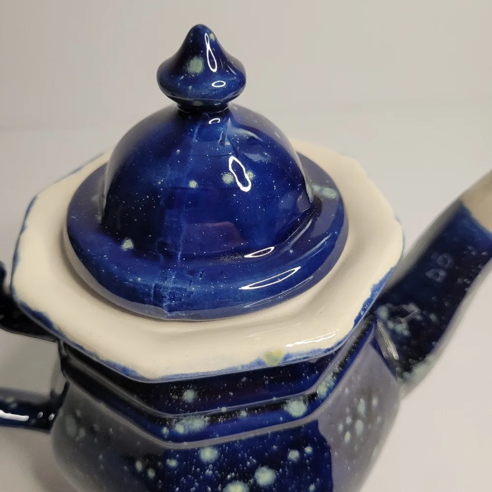 A blue and white speckled teapot. 271